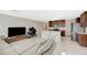 Open-concept living room features a kitchen with an island and a comfortable sofa at 5691 Tinar St, Las Vegas, NV 89113