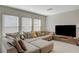 Comfortable living room with a large sectional sofa, a television, and natural light from the windows at 5691 Tinar St, Las Vegas, NV 89113