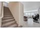 Open-concept space leading from carpeted stairs to a living room with bright tile flooring at 5691 Tinar St, Las Vegas, NV 89113