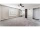 Neutral bedroom with a ceiling fan, plush carpeting, and mirrored closet doors at 6425 Goldmine Dr, Las Vegas, NV 89156