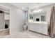 Neutral toned bathroom with double sinks, large mirror, tiled flooring, and a walk-in closet nearby at 6619 Frosted Harvest Ave, Las Vegas, NV 89108