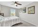 Comfortable bedroom features neutral walls, ceiling fan, carpet and natural light at 6619 Frosted Harvest Ave, Las Vegas, NV 89108