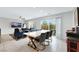 Bright dining area featuring a long table with seating and a sliding door to the backyard at 6619 Frosted Harvest Ave, Las Vegas, NV 89108