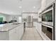 Spacious kitchen with white cabinets, granite countertops, stainless steel appliances, and an open layout connecting living spaces at 6619 Frosted Harvest Ave, Las Vegas, NV 89108