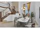 Dining area featuring a marble table, chandelier, staircase with decorative railings, and large sunlit windows at 738 Panhandle Dr, Henderson, NV 89014