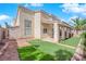 A two-story home features a stucco facade, tile roof, and a cozy backyard with synthetic lawn at 738 Panhandle Dr, Henderson, NV 89014