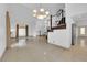 An open-plan living area featuring a high ceiling, large sunlit windows, and adjacent staircase with decorative railings at 738 Panhandle Dr, Henderson, NV 89014