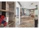 Large bathroom features a bathtub with steps, marble walls and floors, and decorative artwork at 7436 Oak Grove Ave, Las Vegas, NV 89117