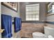 Bathroom featuring blue towels, patterned tiled walls, and a unique glass block window for natural lighting at 7436 Oak Grove Ave, Las Vegas, NV 89117