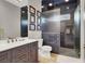 Modern bathroom featuring a vanity with a large mirror and walk-in shower with stylish dark tiling at 7436 Oak Grove Ave, Las Vegas, NV 89117