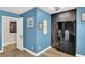 Kitchenette area with black refrigerator and blue accent walls at 7436 Oak Grove Ave, Las Vegas, NV 89117