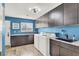Laundry room features granite counters, washer, dryer, and blue accent wall at 7436 Oak Grove Ave, Las Vegas, NV 89117