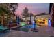 Backyard pool with seating area, decorative tile, and lush vegetation at dusk at 7436 Oak Grove Ave, Las Vegas, NV 89117