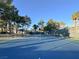 Well-maintained community tennis court with a net, surrounded by lush greenery, offering a great space for recreation at 7436 Oak Grove Ave, Las Vegas, NV 89117