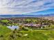 Stunning aerial view showcasing the lush green golf course, clubhouse, lake, and expansive community at 7711 Spanish Lake Dr, Las Vegas, NV 89113
