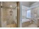 This bathroom features a tiled shower and a soaking tub underneath a window at 7711 Spanish Lake Dr, Las Vegas, NV 89113