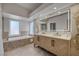 Bright bathroom featuring a double vanity, soaking tub, and recessed lighting at 7711 Spanish Lake Dr, Las Vegas, NV 89113