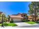 Inviting two-story home with a two-car garage, lush lawn, and mature shade tree at 7711 Spanish Lake Dr, Las Vegas, NV 89113
