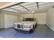 Clean garage featuring white storage cabinets, light grey flooring, and a vintage car at 7711 Spanish Lake Dr, Las Vegas, NV 89113