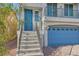 Inviting home entrance with stairs, a blue front door, and views to a garage at 7745 Tyrell Peaks St, Las Vegas, NV 89139