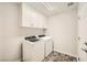 Efficient laundry room with modern washer, dryer, and overhead storage cabinets at 7745 Tyrell Peaks St, Las Vegas, NV 89139