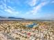Scenic aerial view featuring a residential area near a blue lake, beneath a partly cloudy sky at 8005 Dover Shores Ave, Las Vegas, NV 89128