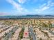 Broad aerial image showcasing a neighborhood with light-roofed houses, set against a backdrop of distant mountains at 8005 Dover Shores Ave, Las Vegas, NV 89128