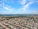 Extensive aerial perspective of a community with neatly arranged homes and palm trees, under a bright sky at 8005 Dover Shores Ave, Las Vegas, NV 89128