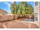 Private backyard featuring desert landscaping, mature trees, and a paved patio area at 8005 Dover Shores Ave, Las Vegas, NV 89128