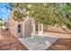 Rear view of home featuring desert landscaping, a large concrete patio, a white fence, and access to yard at 8005 Dover Shores Ave, Las Vegas, NV 89128