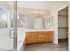 Bathroom featuring double sinks, wood cabinets, a glass enclosed shower and a soaking tub with a window at 8005 Dover Shores Ave, Las Vegas, NV 89128
