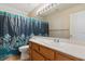 Bright bathroom featuring a floral shower curtain, a spacious countertop and a large mirror with vanity lighting at 8005 Dover Shores Ave, Las Vegas, NV 89128