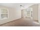 Spacious bedroom featuring a ceiling fan, carpet flooring, and plenty of natural light from multiple windows at 8005 Dover Shores Ave, Las Vegas, NV 89128