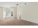 Large carpeted bedroom with vaulted ceiling, a ceiling fan, a bathroom entrance, and multiple windows at 8005 Dover Shores Ave, Las Vegas, NV 89128