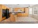 Bright eat-in kitchen featuring a center island, wooden cabinets, granite counters, and black appliances at 8005 Dover Shores Ave, Las Vegas, NV 89128