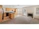 Open concept kitchen features wood cabinets, granite countertops, an island, and a cozy fireplace at 8005 Dover Shores Ave, Las Vegas, NV 89128