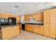 Well-lit kitchen features wooden cabinets, granite countertops, and black appliances at 8005 Dover Shores Ave, Las Vegas, NV 89128