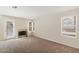 Cozy living room with a fireplace, a door to the backyard, and large windows for plenty of light at 8005 Dover Shores Ave, Las Vegas, NV 89128