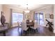 Dining room with a round wood table, upholstered chairs, chandelier and bright, natural lighting at 809 Lake Hill Dr, Boulder City, NV 89005