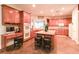 Well-equipped kitchen featuring custom cabinetry, granite island, double ovens, and tile flooring at 809 Lake Hill Dr, Boulder City, NV 89005