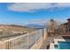 Beautiful desert view from the poolside with mountain backdrop, blue skies, and white fencing at 809 Lake Hill Dr, Boulder City, NV 89005
