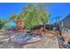 Backyard featuring mature landscaping, a playhouse with a slide, seating area with fire pit and lounging chairs at 8633 Radiant Ruby Ave, Las Vegas, NV 89143