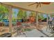 View of covered patio leading to a unique backyard featuring a playhouse, seating area, and mature landscaping at 8633 Radiant Ruby Ave, Las Vegas, NV 89143