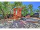 Fun backyard featuring a playhouse with swing, a seating area with fire pit and mature landscaping at 8633 Radiant Ruby Ave, Las Vegas, NV 89143