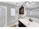 Well-lit bathroom features a dark vanity, white countertops, modern fixtures and a shower with glass doors at 8633 Radiant Ruby Ave, Las Vegas, NV 89143