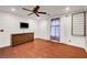 This bedroom includes a ceiling fan, wood floors, a dresser and a window with curtains at 8633 Radiant Ruby Ave, Las Vegas, NV 89143