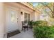 Inviting front entrance featuring a decorative oval glass door, landscaped bushes, and a cozy black chair at 8729 Country View Ave, Las Vegas, NV 89129