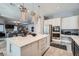 Gourmet kitchen features a large island with quartz countertops, stainless appliances, and elegant pendant lighting at 9611 Trattoria St, Las Vegas, NV 89178