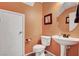 Charming powder room features a pedestal sink and peach colored walls at 9992 Oyster Pearl St, Las Vegas, NV 89183