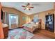 Comfortable bedroom with wood floors, a ceiling fan, neutral-toned walls and a view of the neighborhood at 9992 Oyster Pearl St, Las Vegas, NV 89183